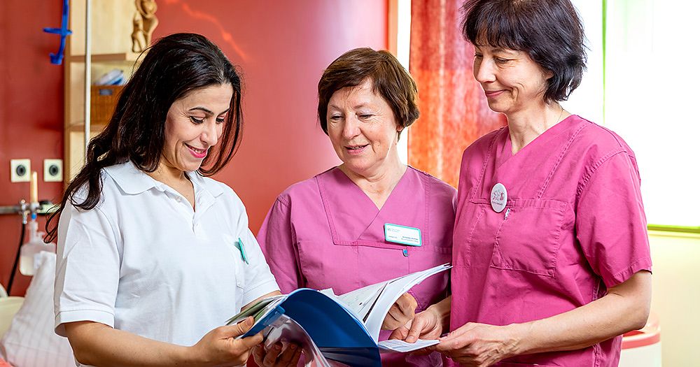 Hebammen und Ärzte bei einer Besprechung, A. Franke